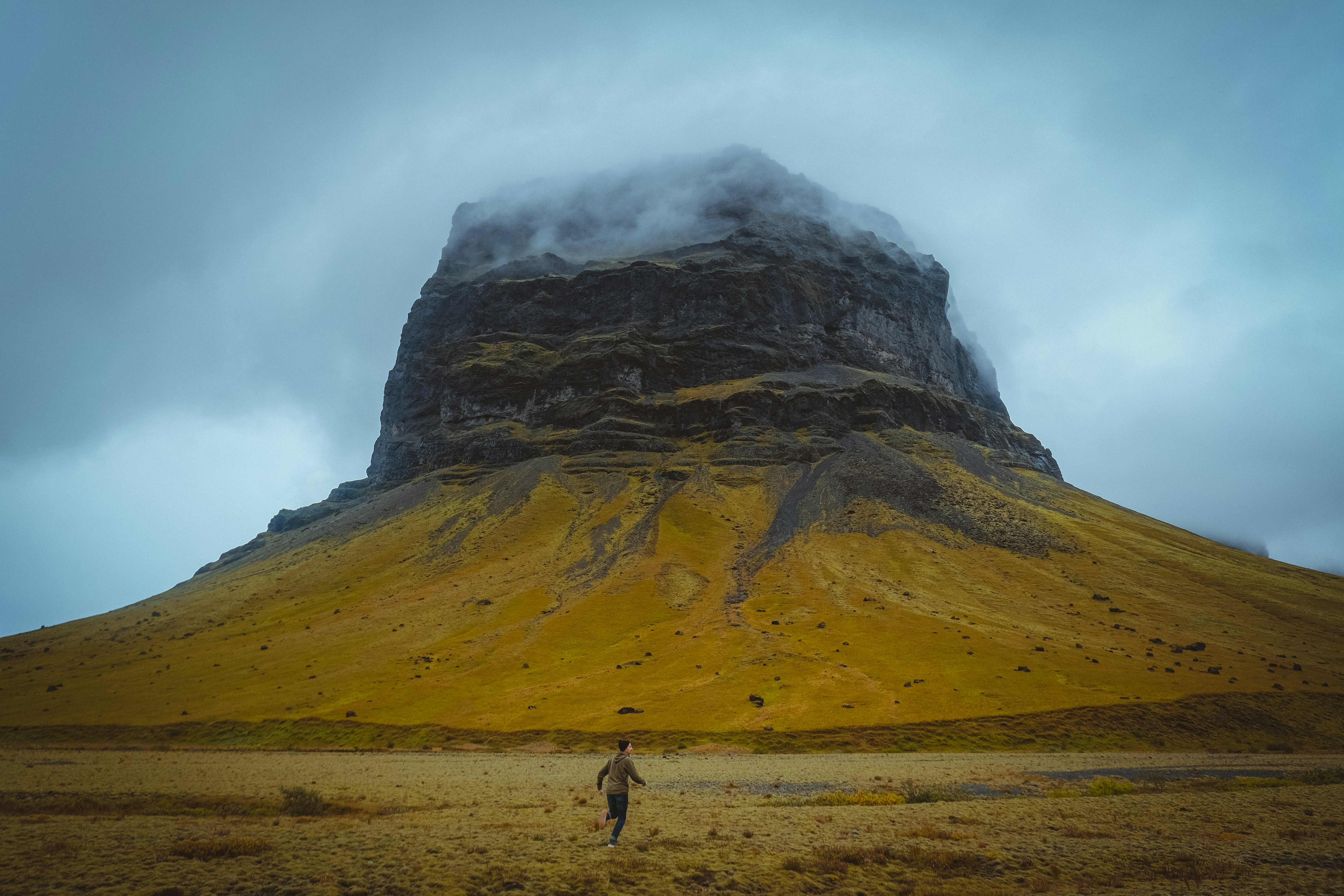 person walking on brown field near mountain during daytime